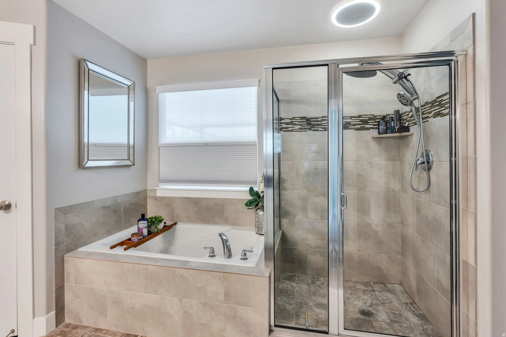 Step-in shower with clear glass enclosure and a separate soaking tub