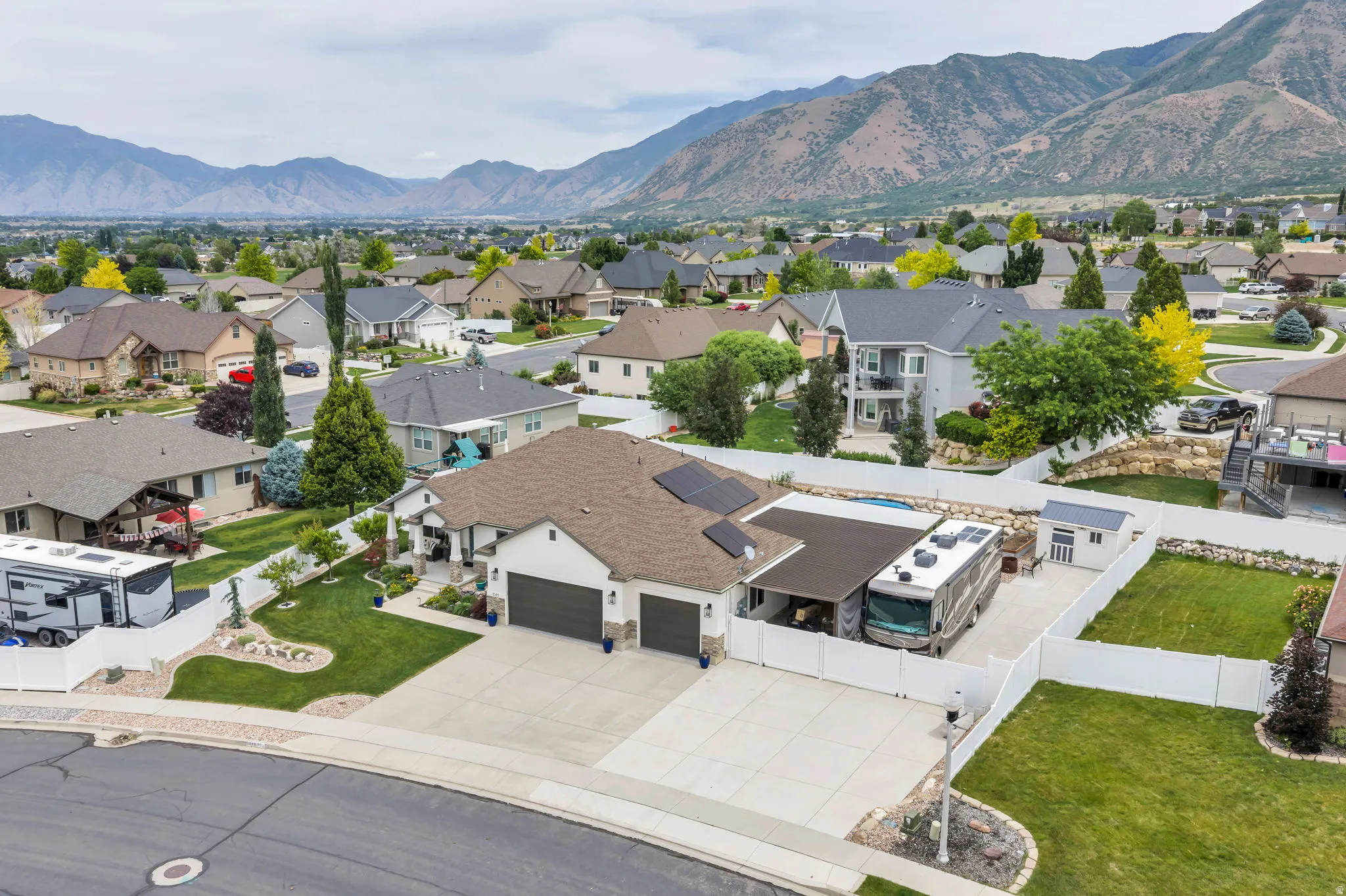 Suburban residence with a multi-car driveway, attached two-car garage, and a covered RV parking pad