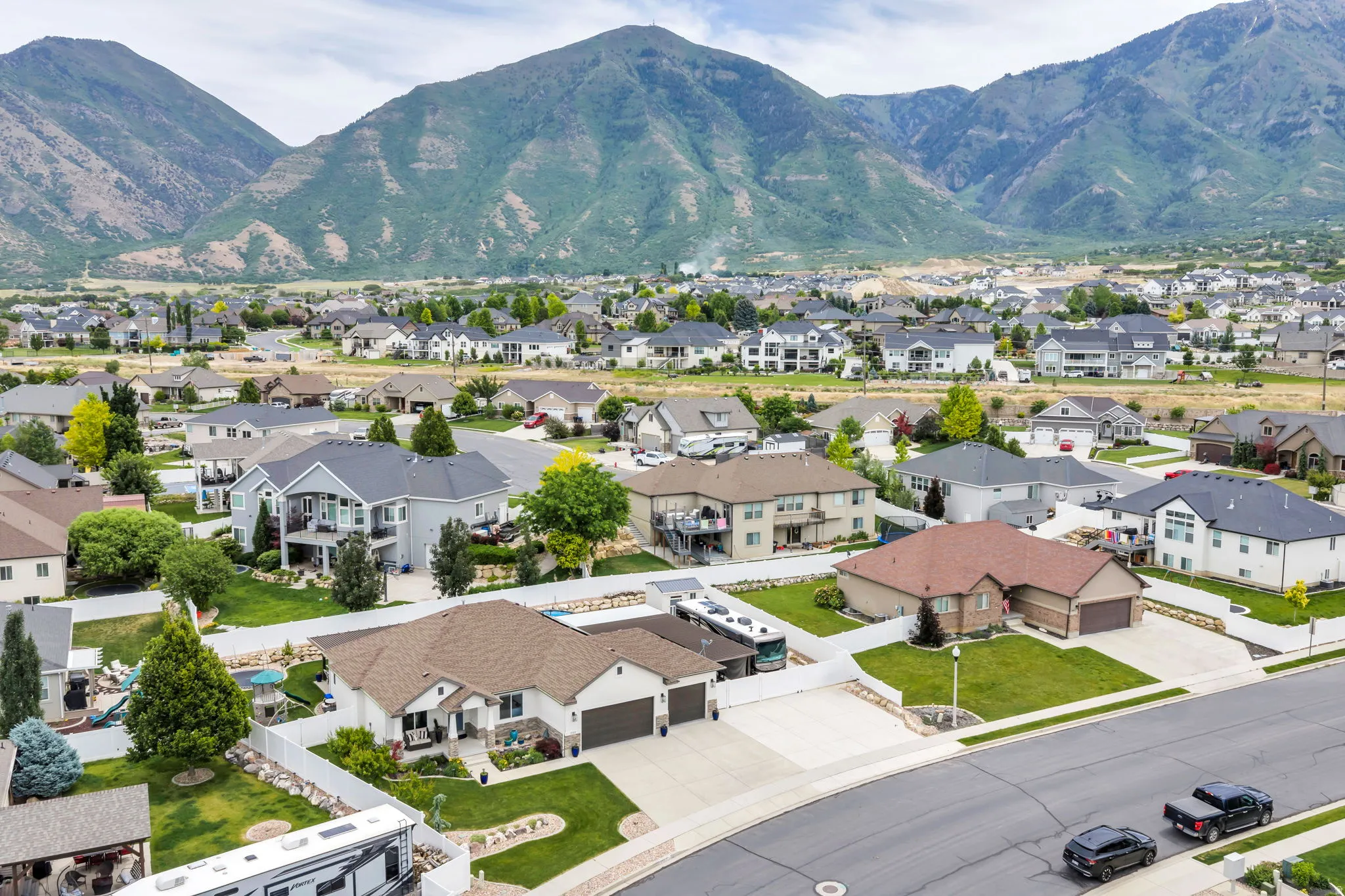 Aerial perspective showcasing a residential community with varied home styles and mountain backdrop