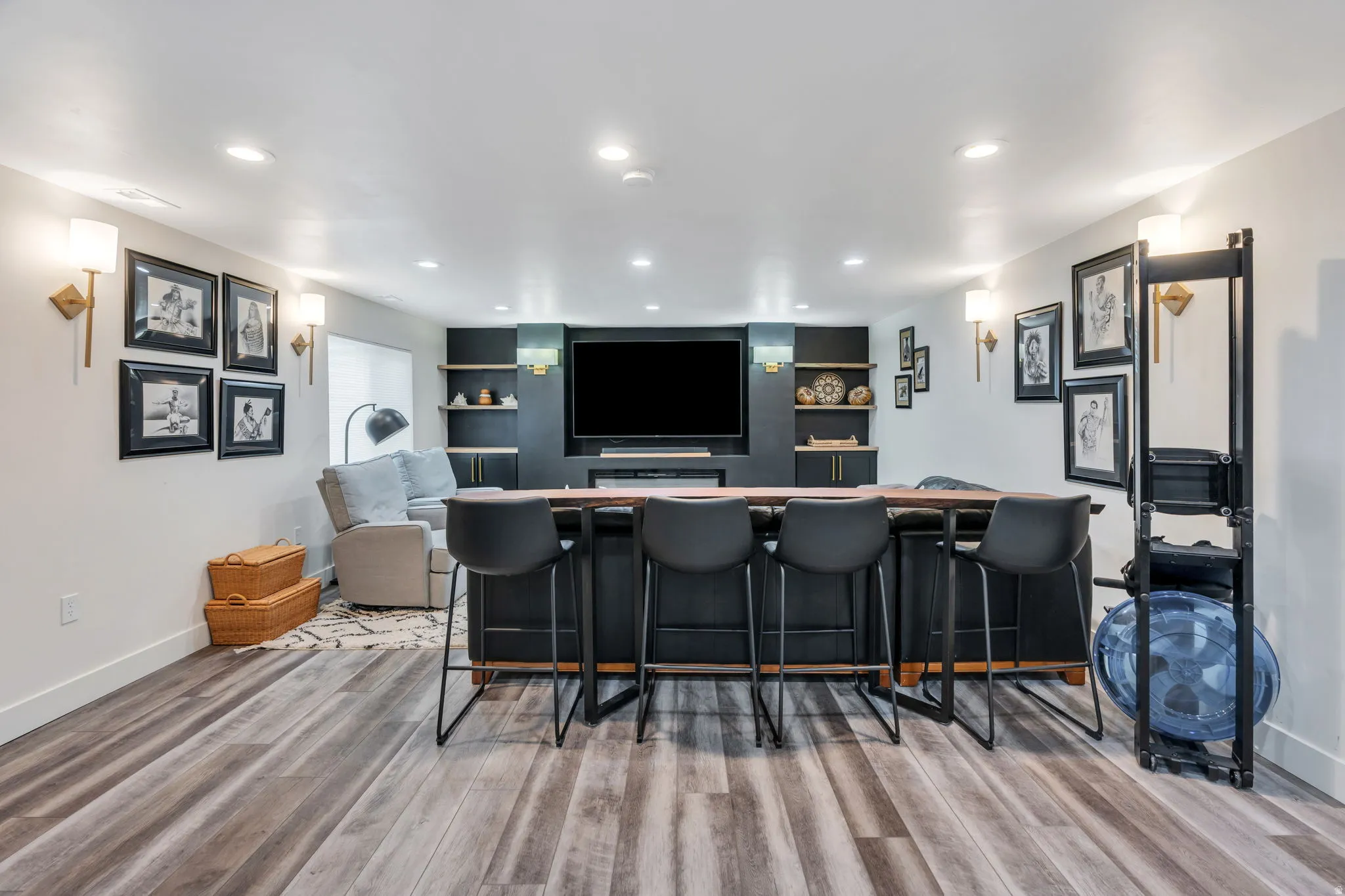 Entertainment area featuring wood-finish flooring, recessed lighting, and wall sconces