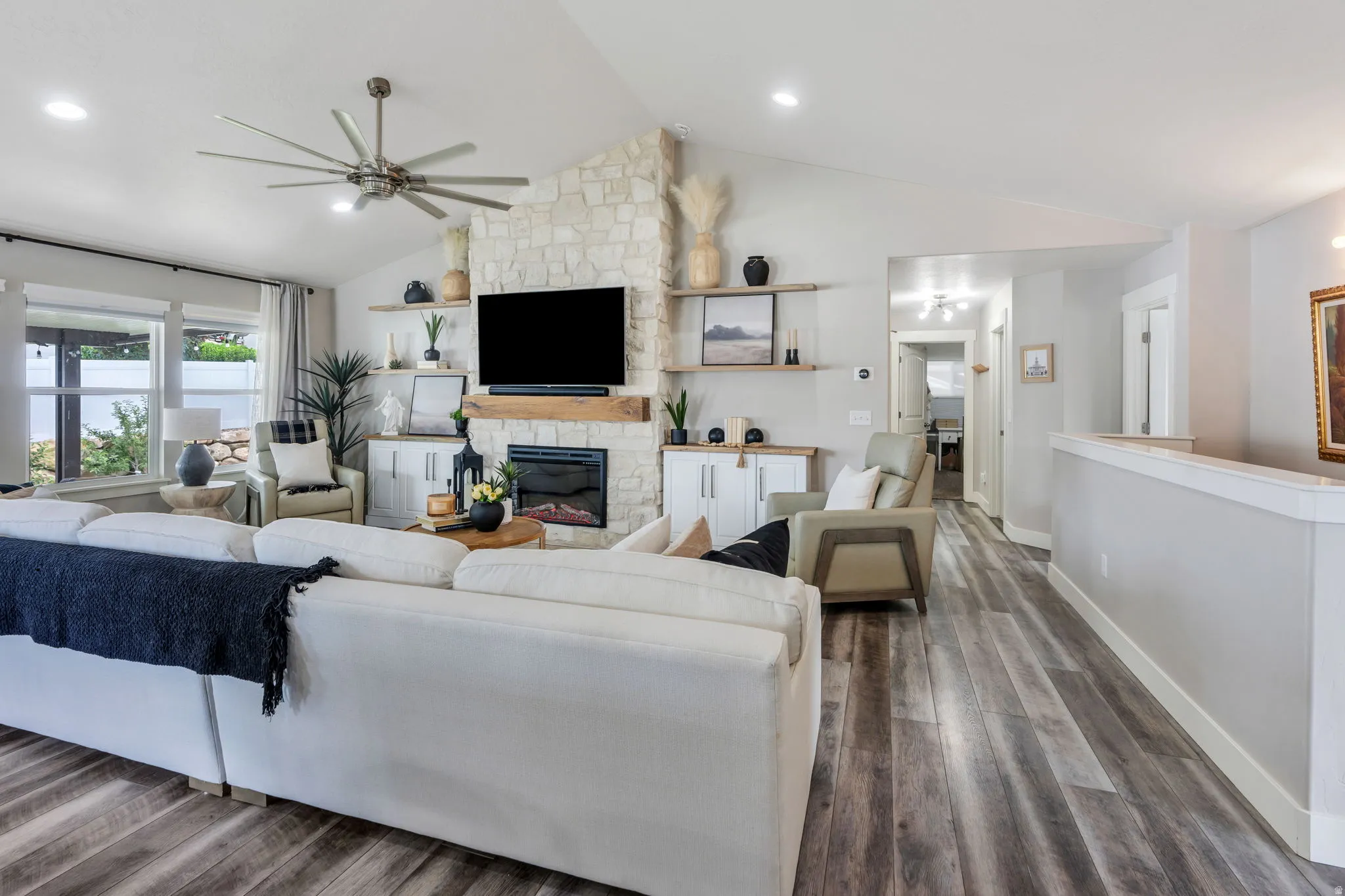 Spacious living area featuring vaulted ceilings, recessed lighting, and wood-finish flooring