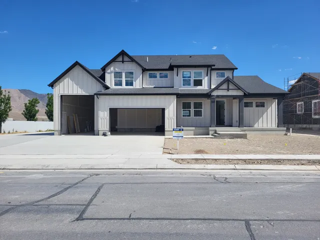 Contemporary two-story residence featuring white vertical and horizontal siding with dark trim accents