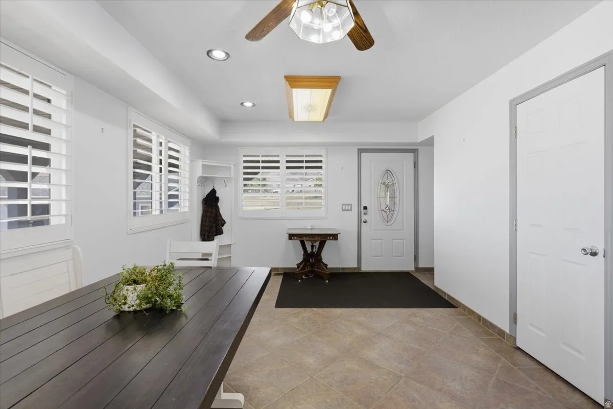 Entry area featuring light-toned tile flooring, recessed lighting, and a front entry door with decorative glass