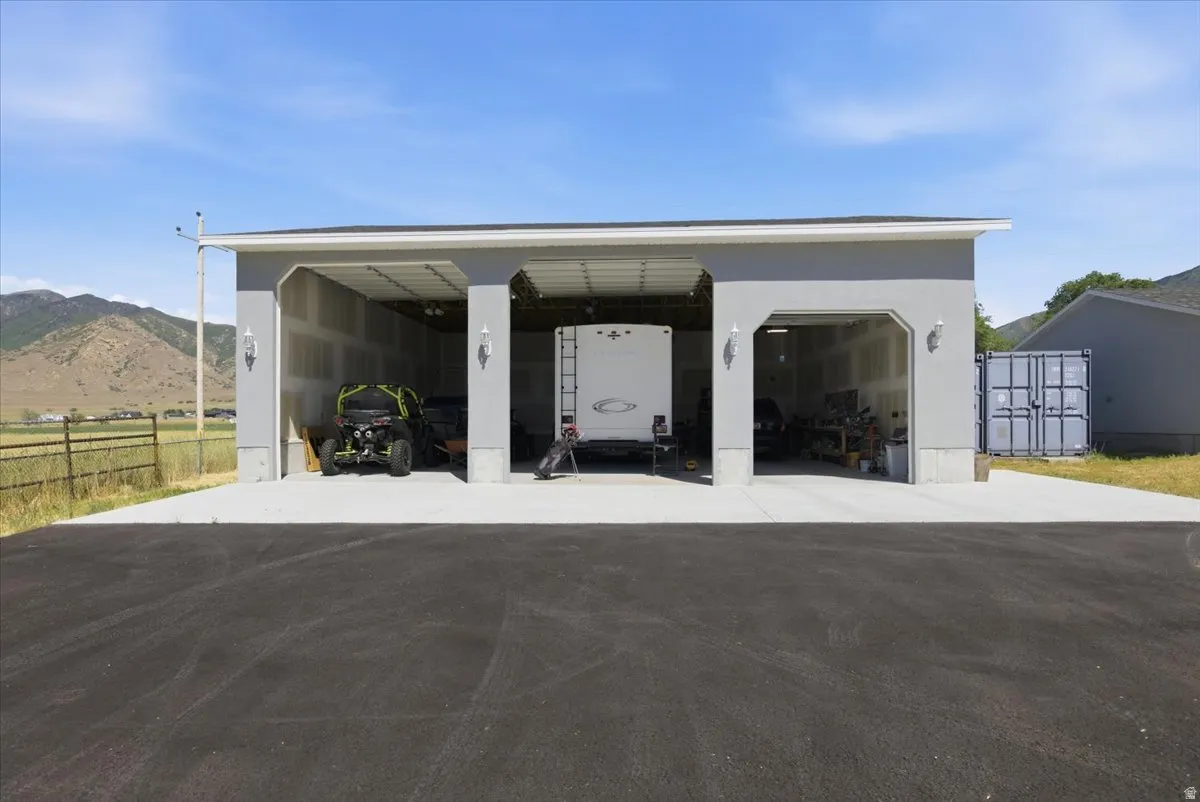 Three-bay garage with concrete flooring and exterior sconce lighting