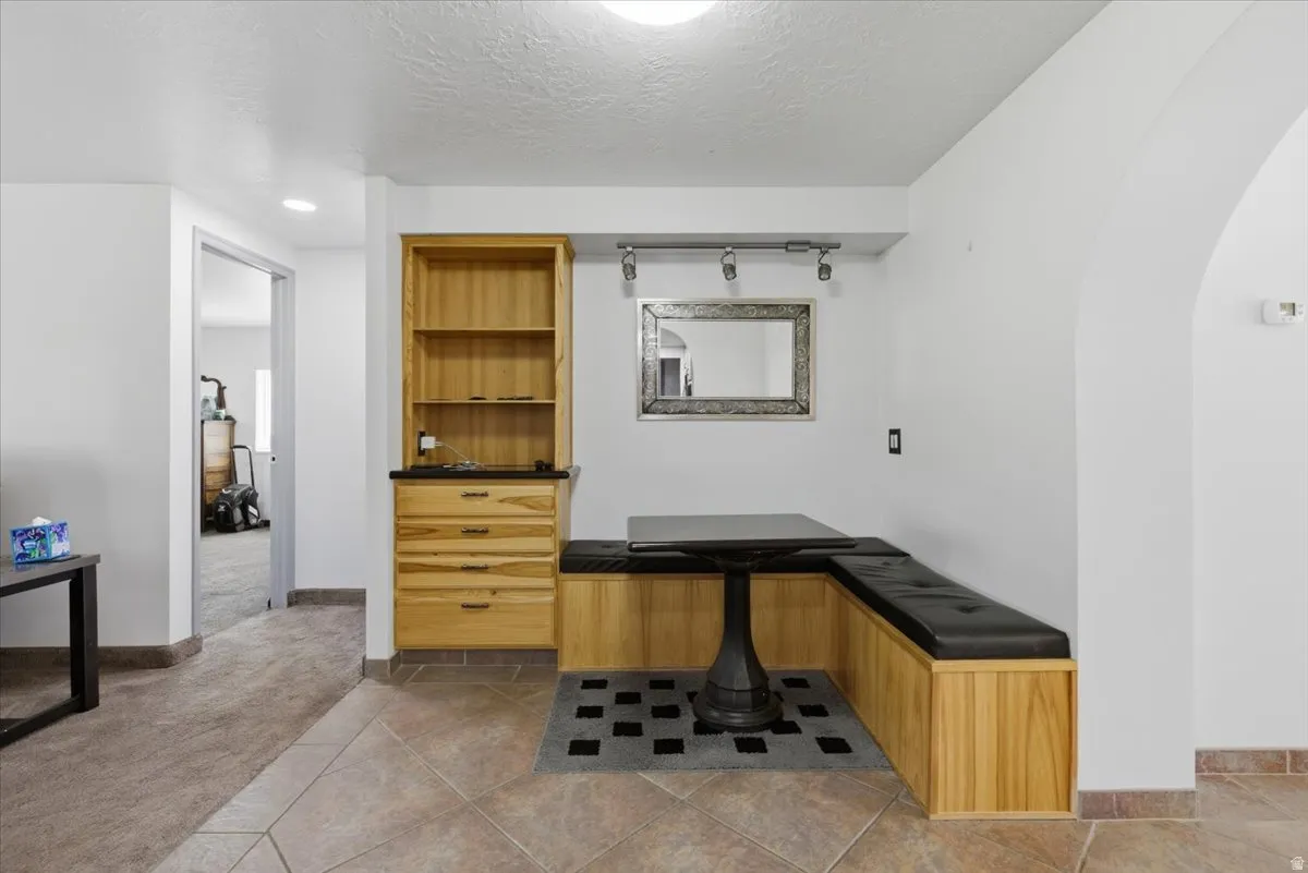 Built-in dining nook with black upholstered seating, a coordinating pedestal table, and an arched architectural detail