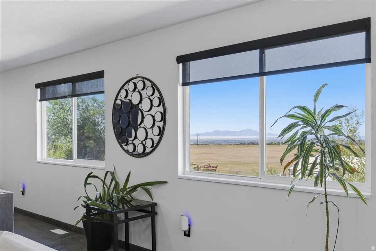Expansive window showcasing mountain and field scenery