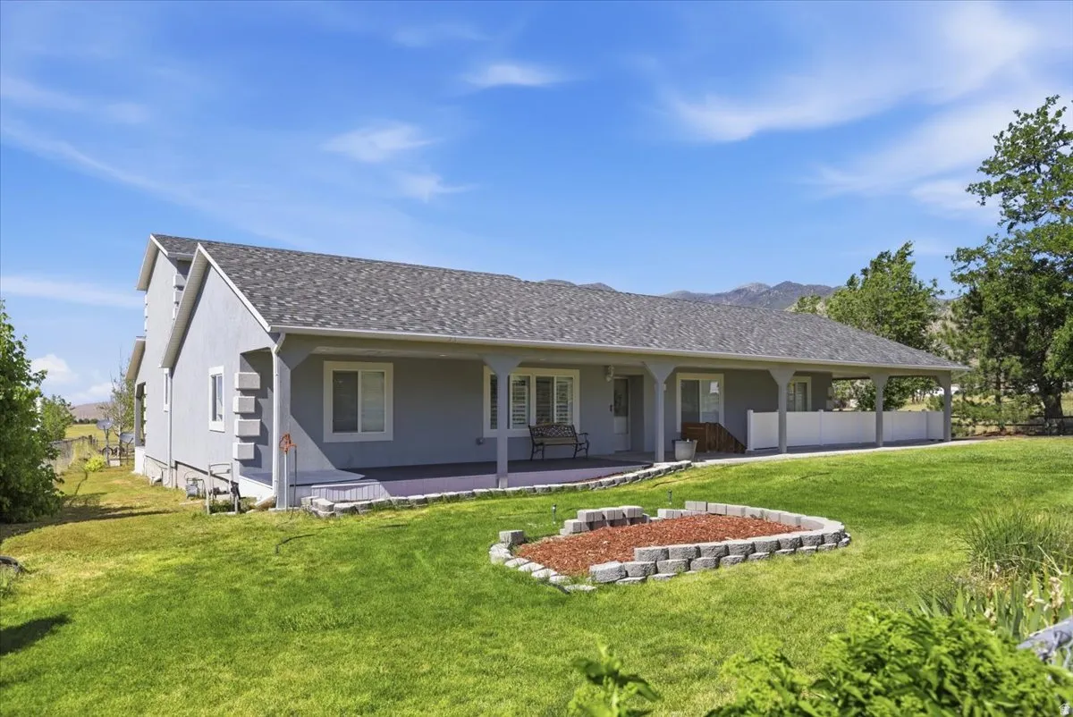 Ranch-style exterior featuring a covered porch, light gray siding, a dark shingle roof, and multiple windows