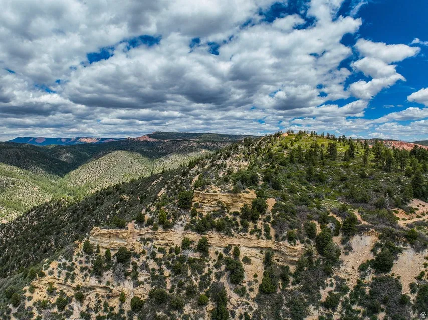 Expansive natural landscape featuring rolling hills and distant mountains
