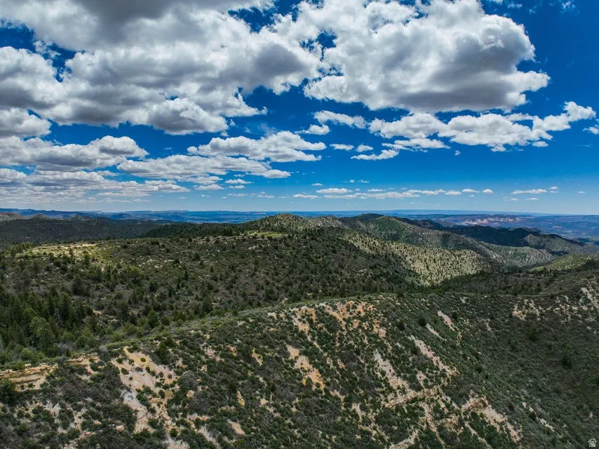 Expansive mountain landscape featuring varied elevations, natural rock formations, and abundant natural vegetation