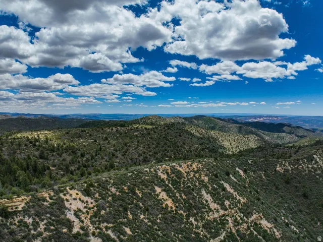 Expansive mountain landscape featuring varied elevations, natural rock formations, and abundant natural vegetation