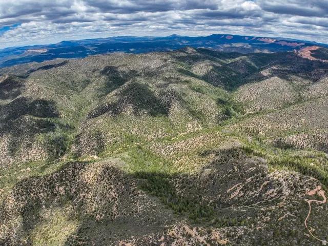 Expansive elevated terrain featuring diverse natural landscaping, distant mountain ranges, and varied topography