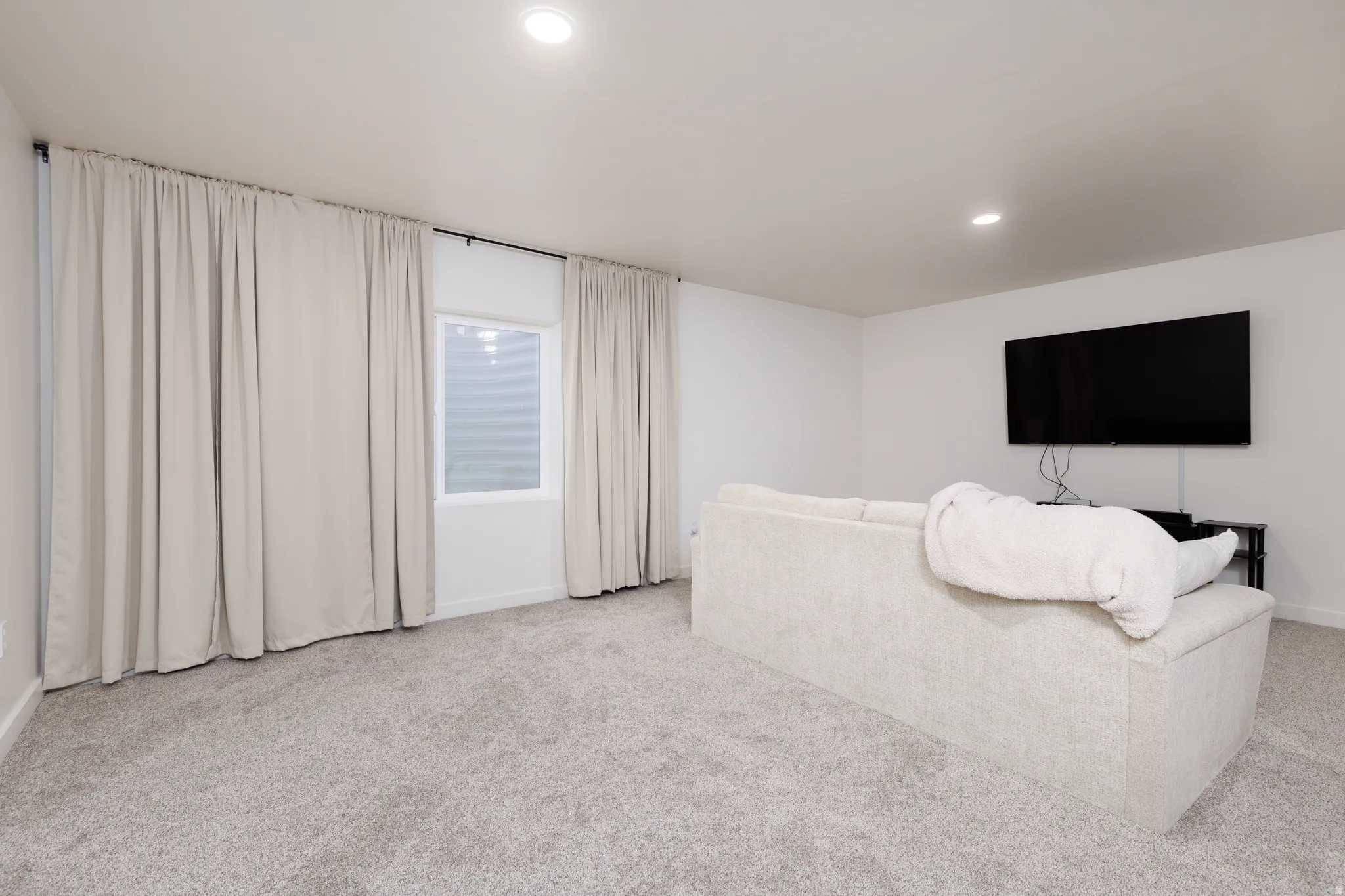 Neutral gray carpeting provides a soft foundation for this space, complemented by crisp white walls and ceiling