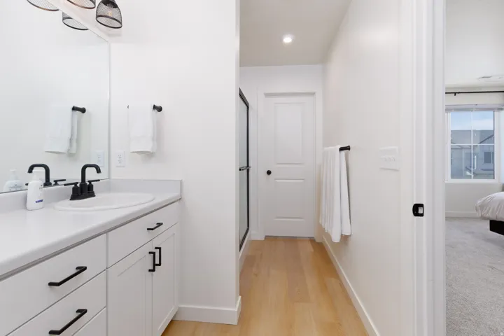 Bathroom vanity with white cabinetry, matte black hardware, and a white countertop