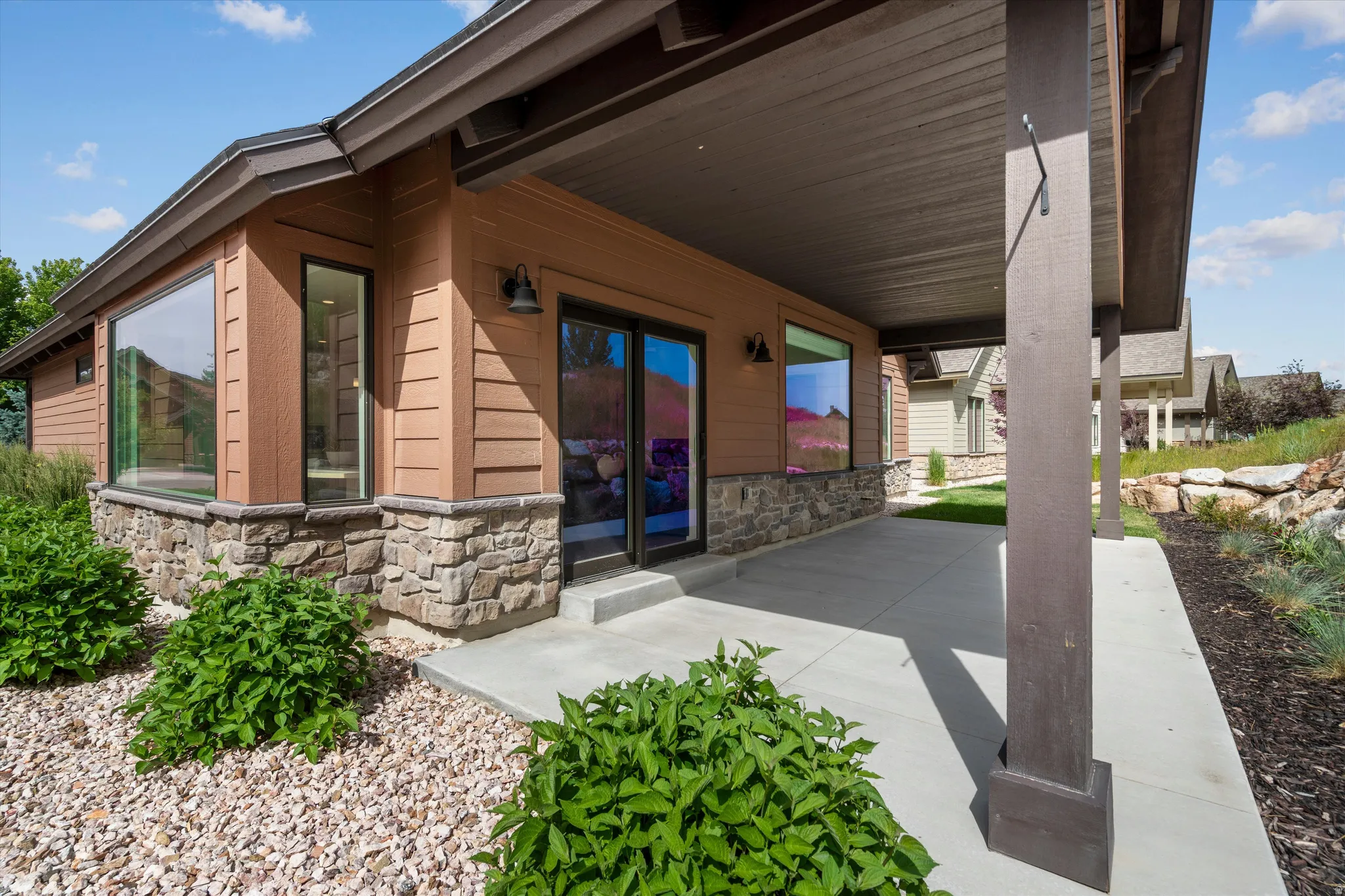 Covered patio featuring a concrete surface and dark-stained support columns.