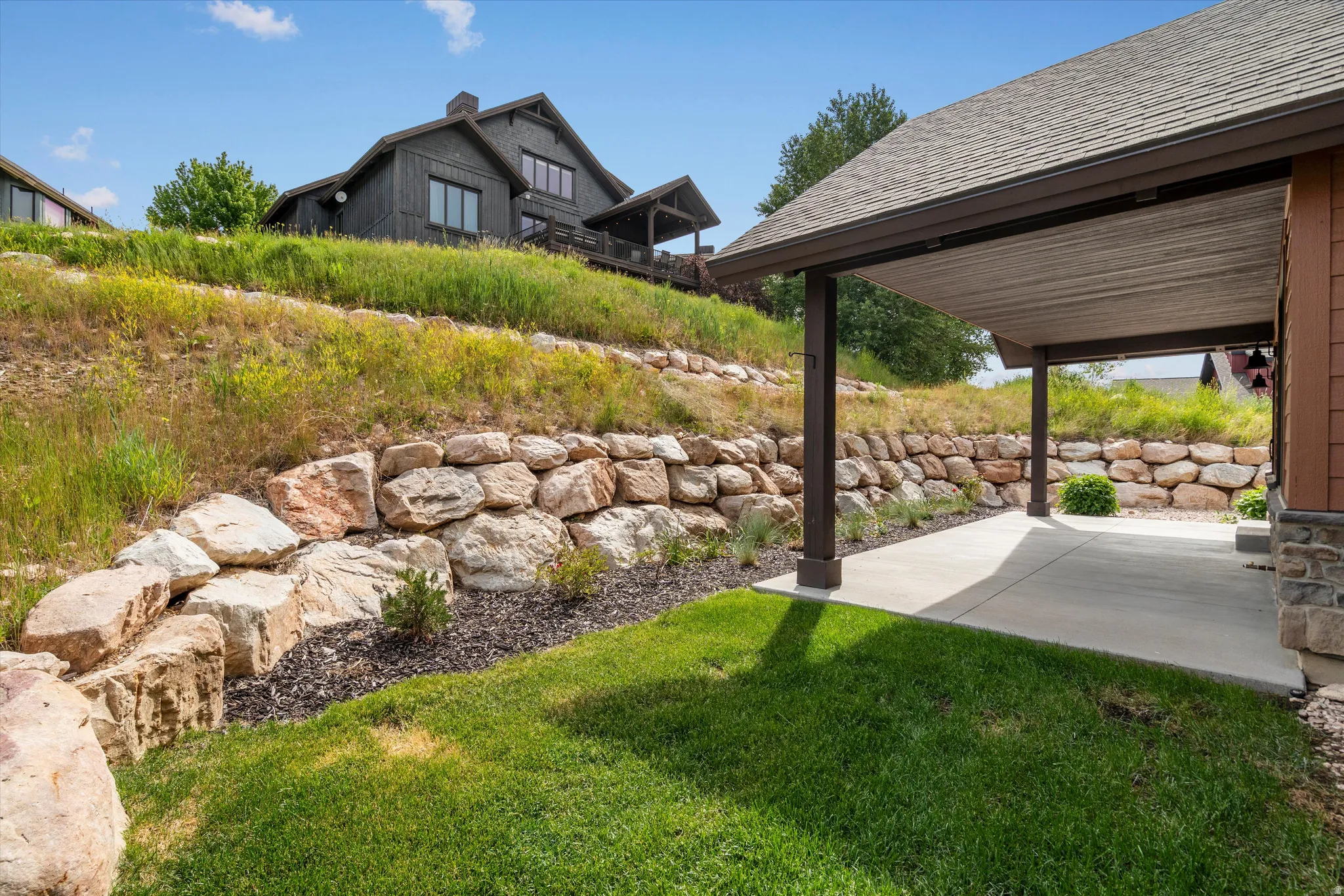 Expansive covered patio featuring a concrete surface and dark support columns.