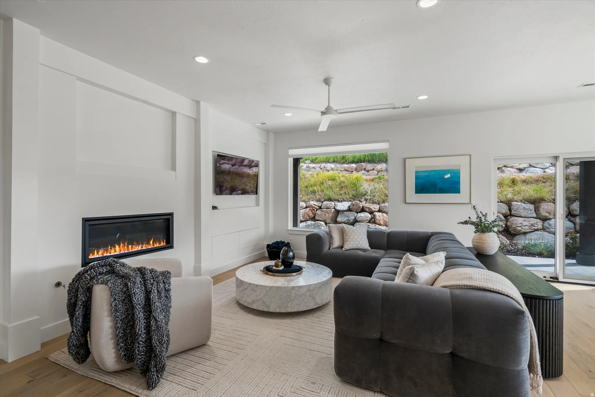 Bright interior featuring fireplace and large picture window.