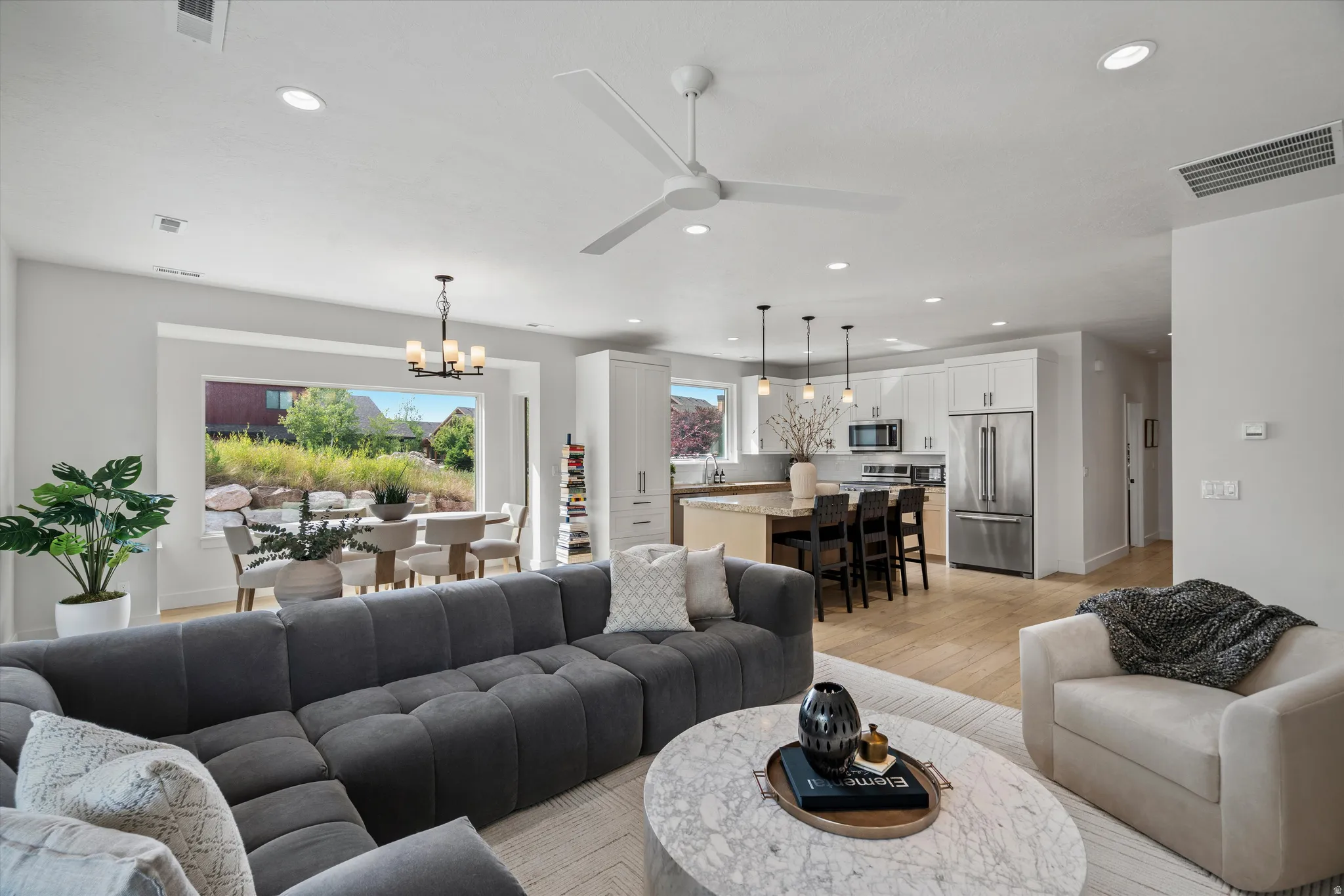 Open-concept living area featuring light wood-finish flooring and recessed lighting.