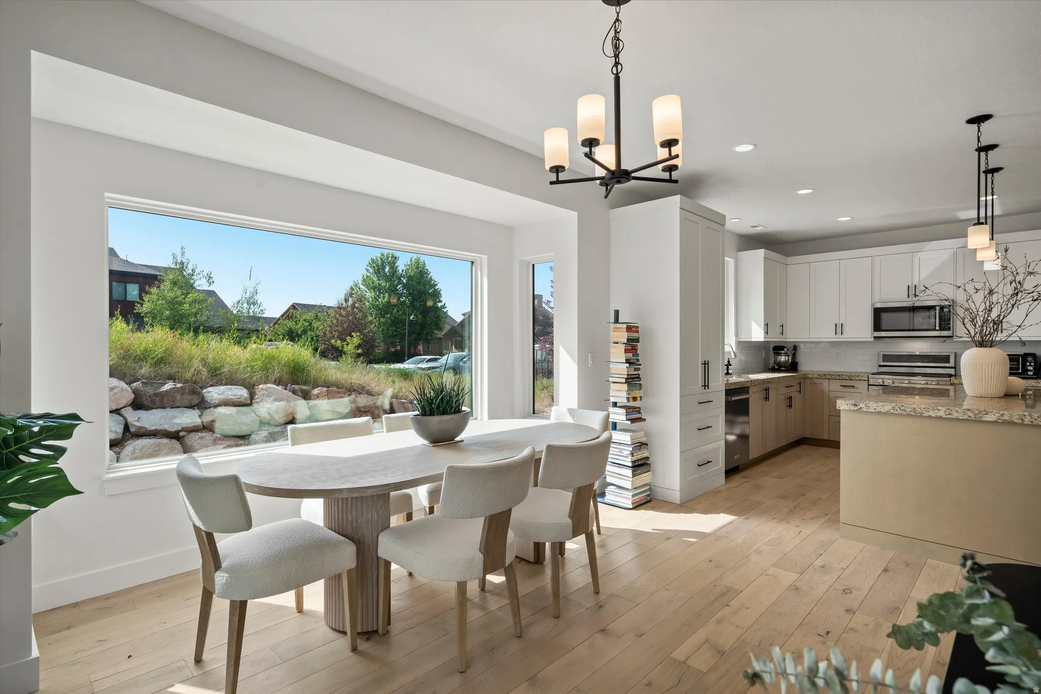 Open-concept dining and kitchen area with light wood-finish flooring