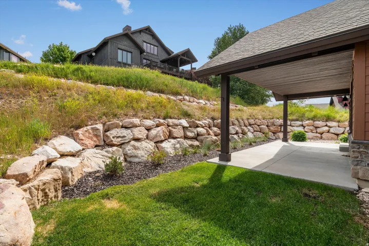 Expansive covered patio featuring a concrete surface and dark support columns.