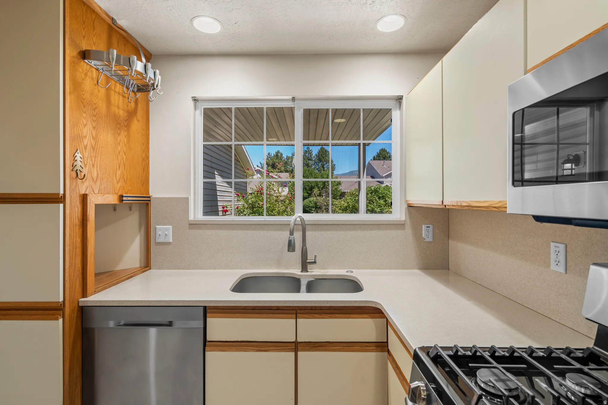 Kitchen featuring a double basin sink, stainless steel dishwasher, and built-in microwave