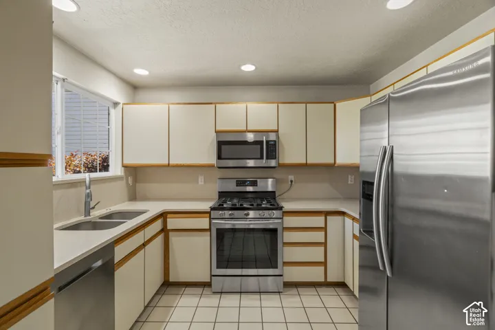 Kitchen featuring stainless steel appliances, light-toned cabinetry, light countertops, and recessed lighting