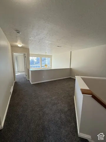 Wall-to-wall carpeting throughout, a white stair railing with a wood-finish top rail, and a semi-flush mount ceiling light