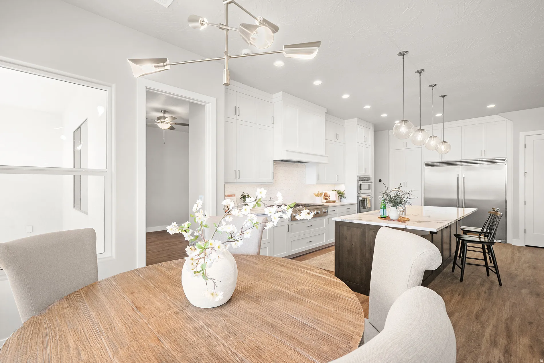 Open-concept kitchen with white cabinetry and integrated stainless steel appliances