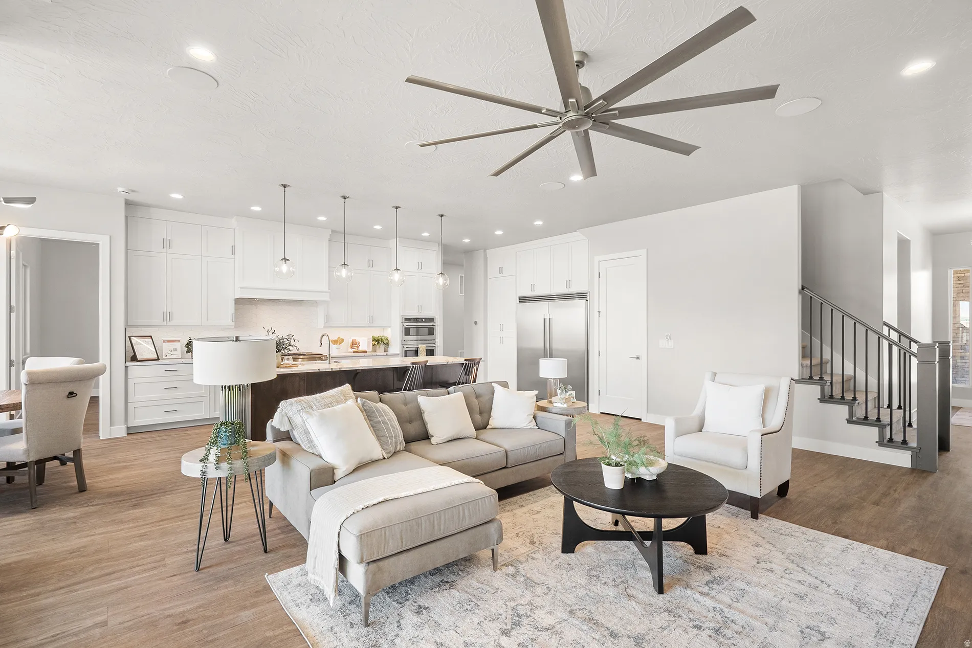 Open-concept living space featuring wood-finish flooring, recessed lighting, and a modern ceiling fan