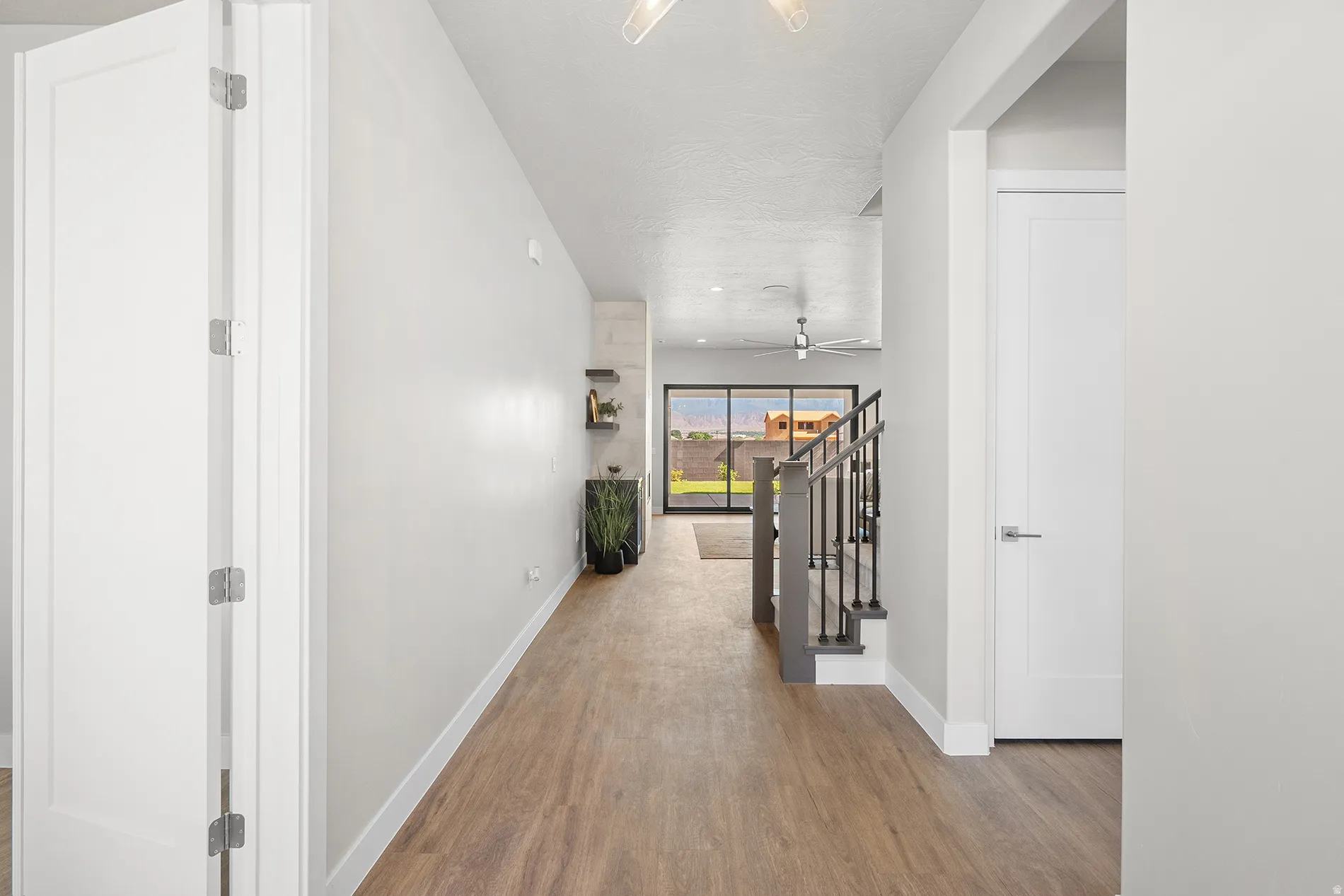 Hallway featuring wood-finish flooring, white walls, and contemporary doors