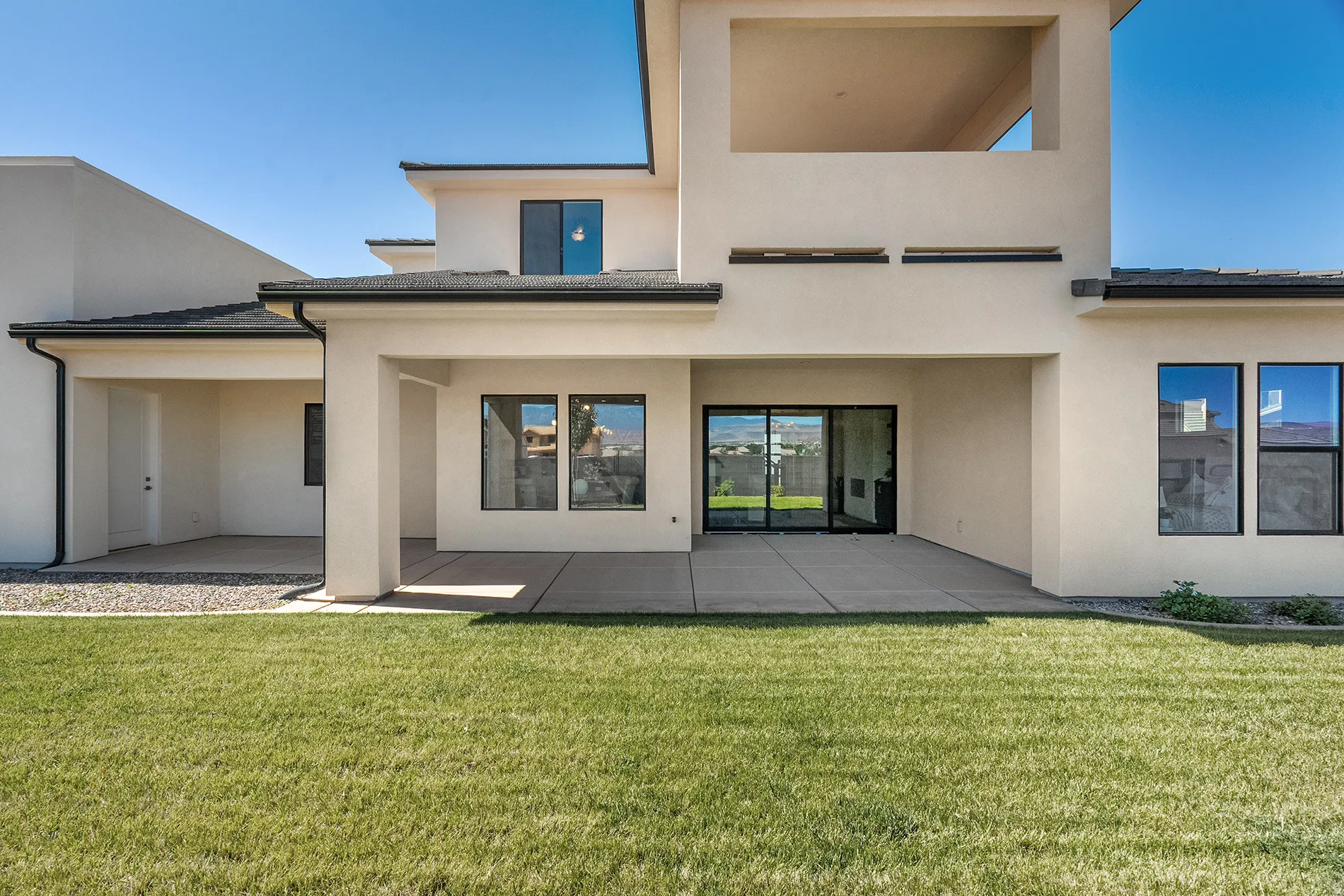 Expansive green lawn with a concrete patio