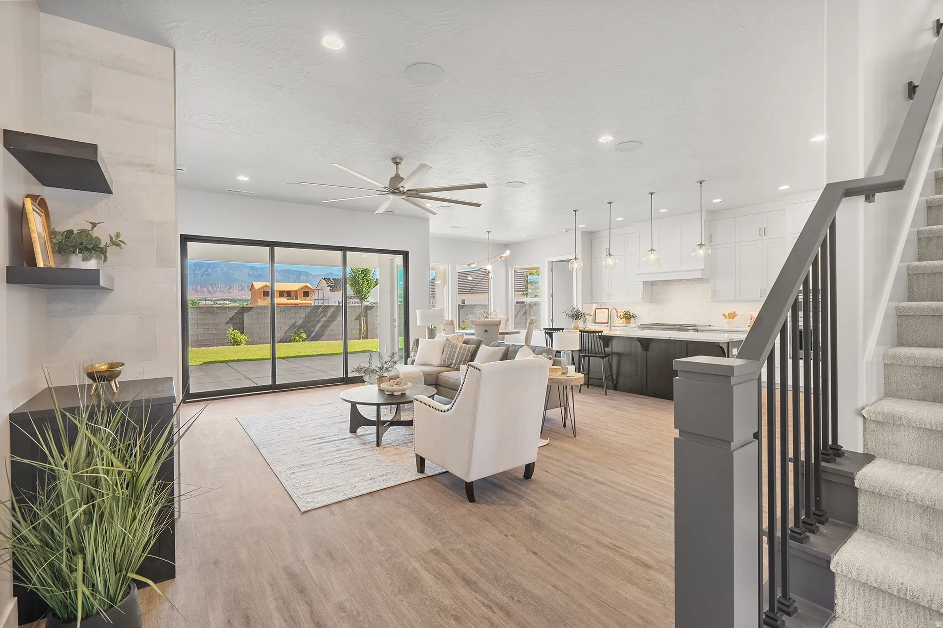 Open-concept living area with wood-finish flooring, recessed lighting, and a modern ceiling fan