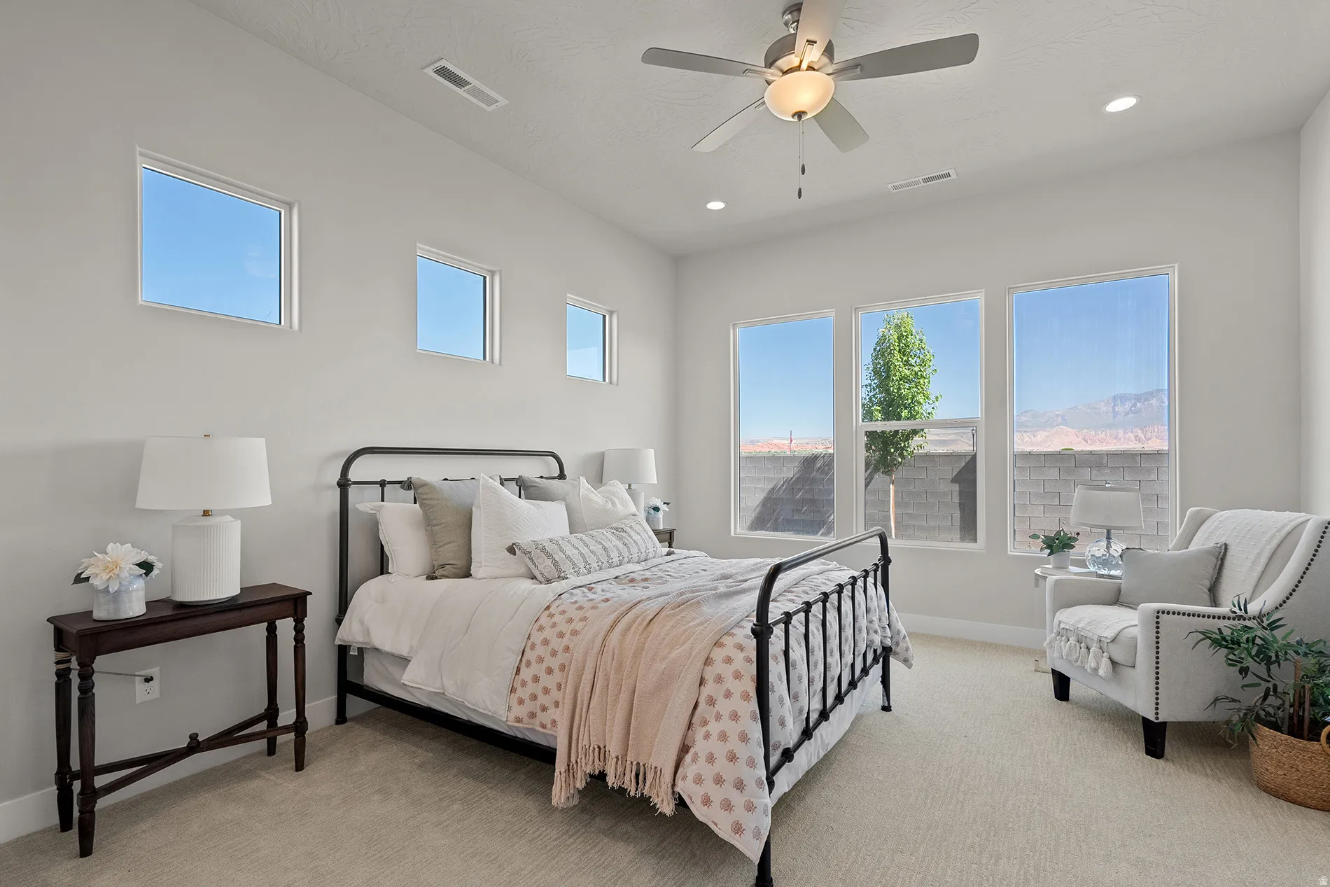 Primary bedroom Carpeted bedroom featuring recessed lighting, a ceiling fan, and multiple windows providing natural illumination and mountain scenery