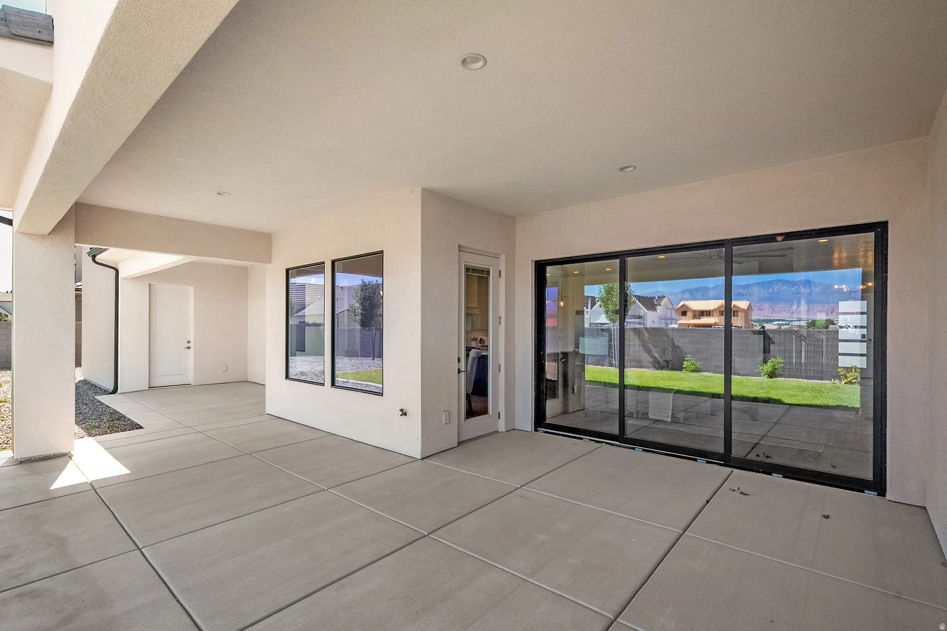 Covered outdoor patio with concrete slab flooring and recessed lighting