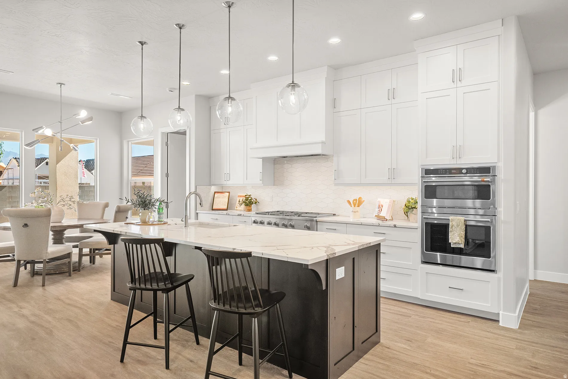 Spacious kitchen featuring an expansive center island with seating, integrated sink, and pendant lighting