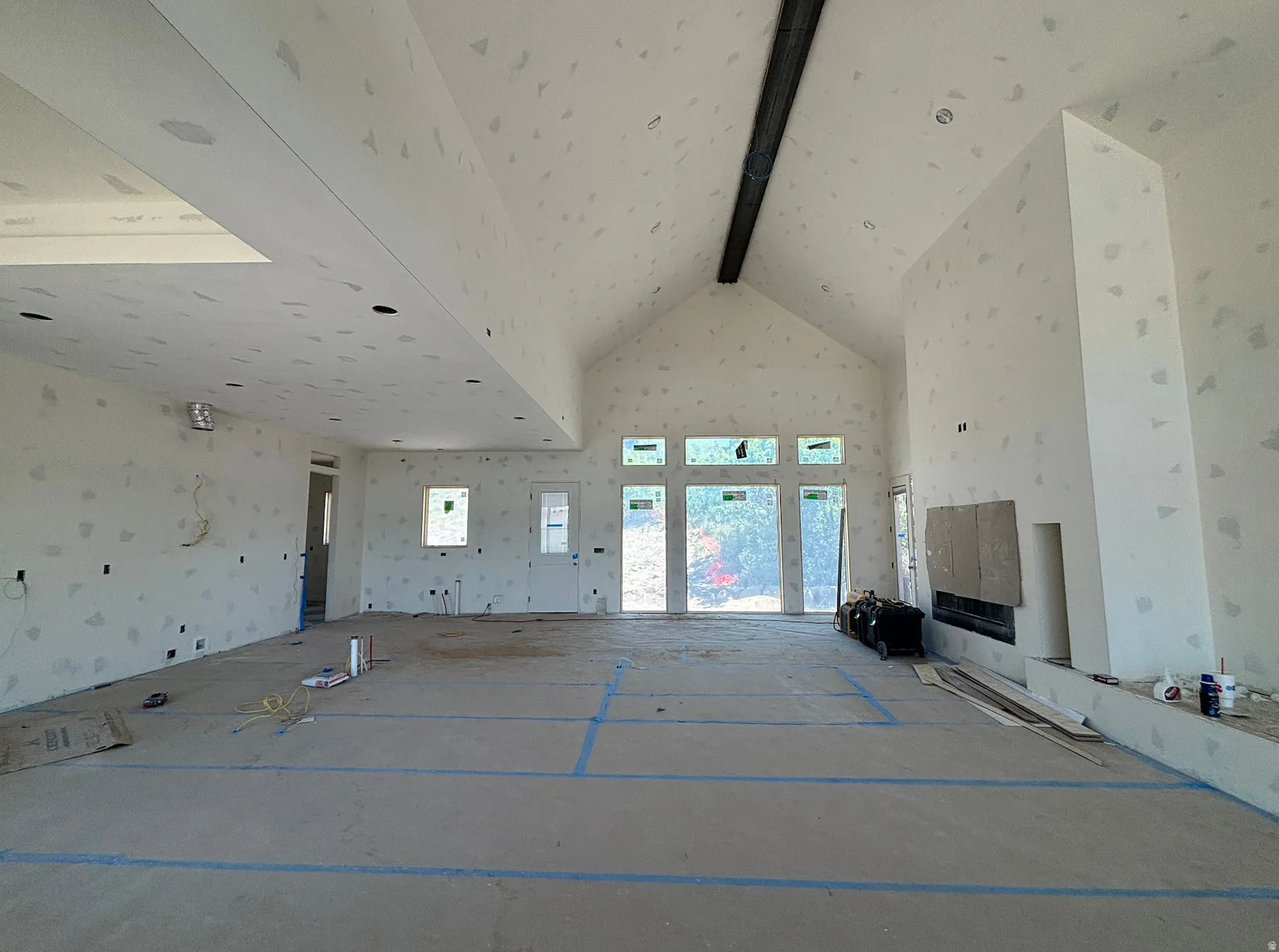 Expansive interior space featuring a vaulted ceiling and an integrated fireplace
