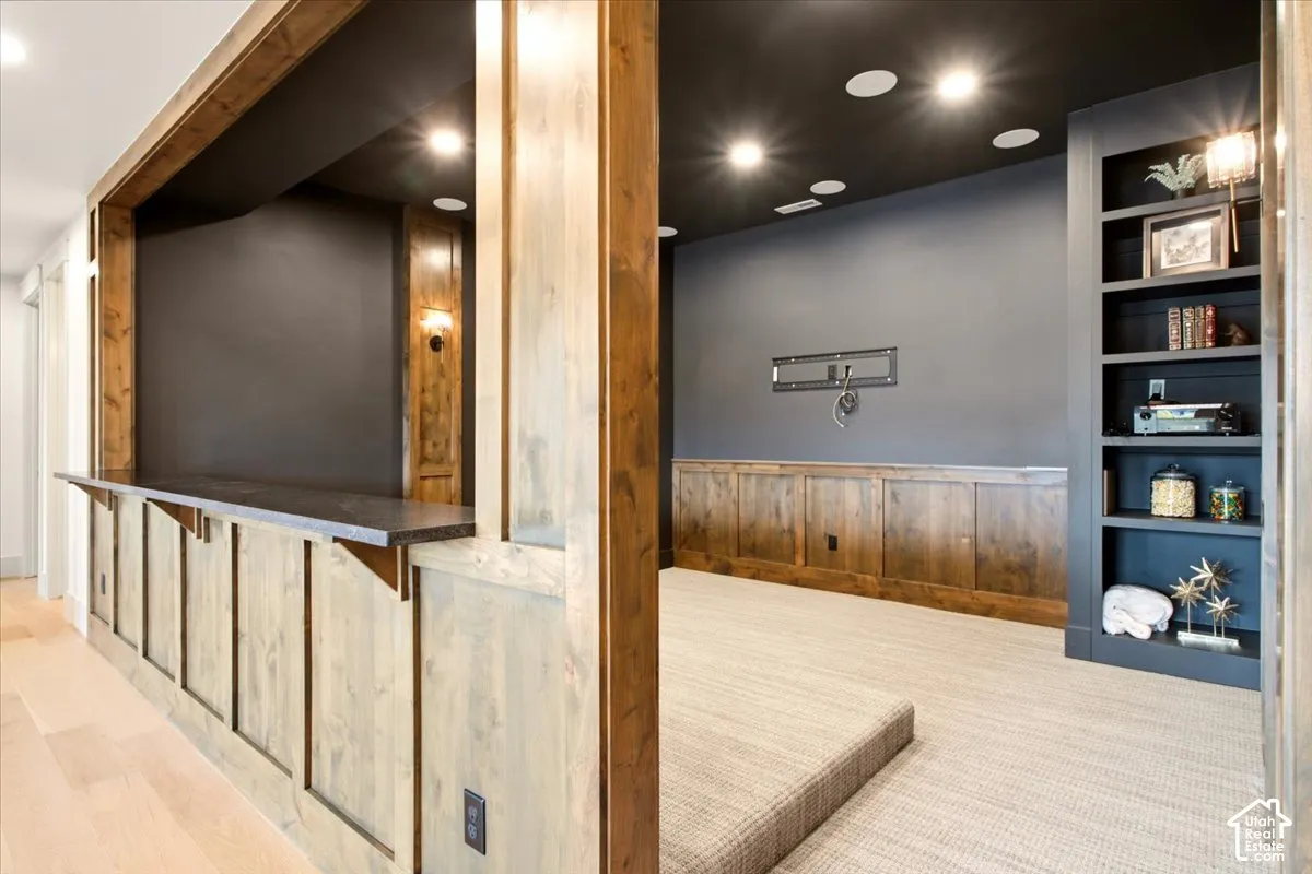 Theater room featuring built-in cabinetry with integrated shelving