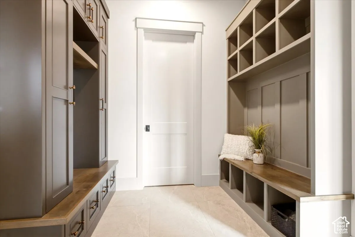 Built-in cabinetry featuring custom storage cubbies, wood-finish bench seating, and integrated wardrobe lockers