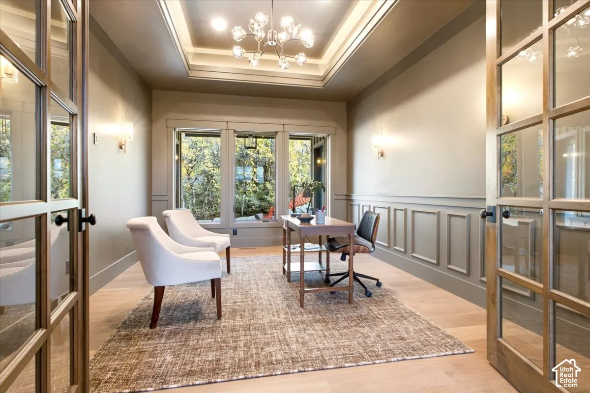 Office/library featuring a tray ceiling with recessed lighting, three large windows, and an expansive doorway