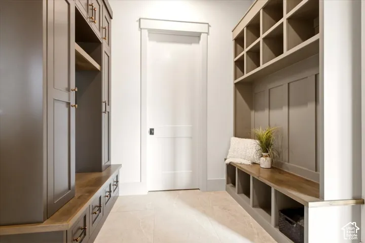 Built-in cabinetry featuring custom storage cubbies, wood-finish bench seating, and integrated wardrobe lockers