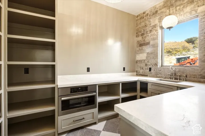 Pantry featuring a built-in stainless steel microwave, and a checkered tile floor