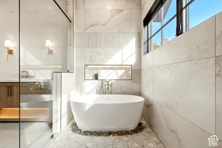 Freestanding oval soaking tub set on a river rock bed