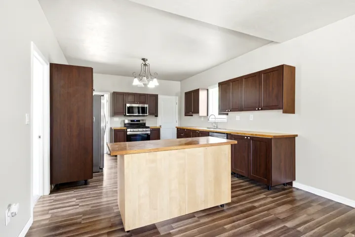 Kitchen featuring a central light wood island with a butcher block top