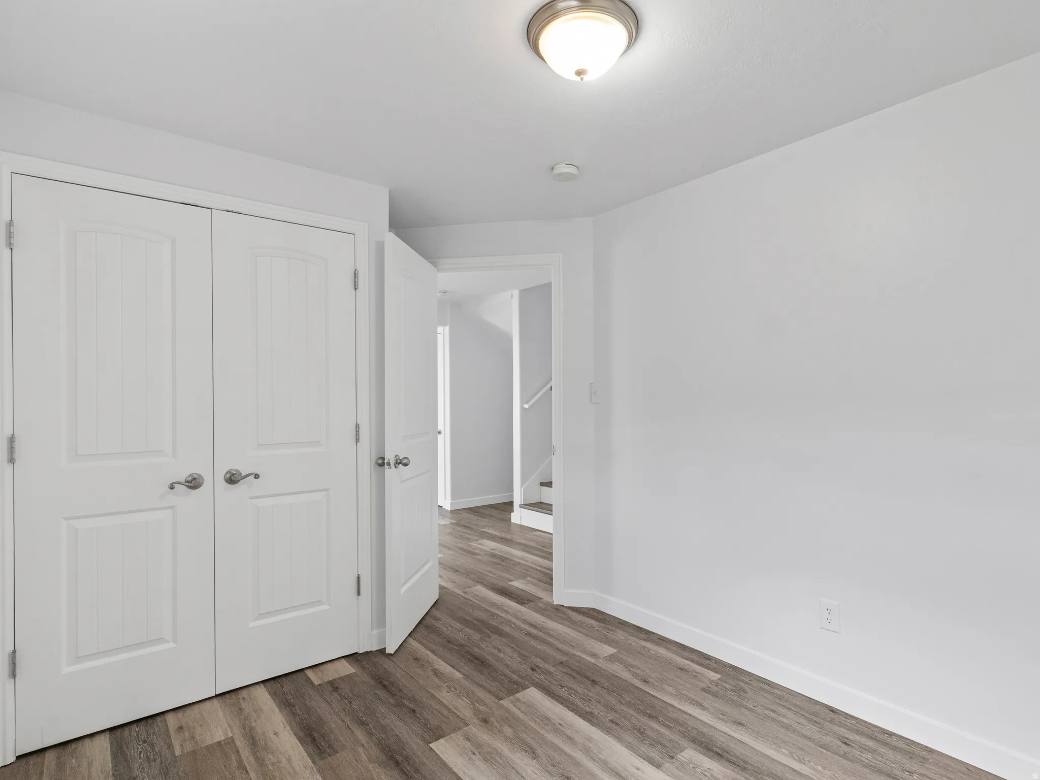 Room featuring wood-finish flooring and white walls