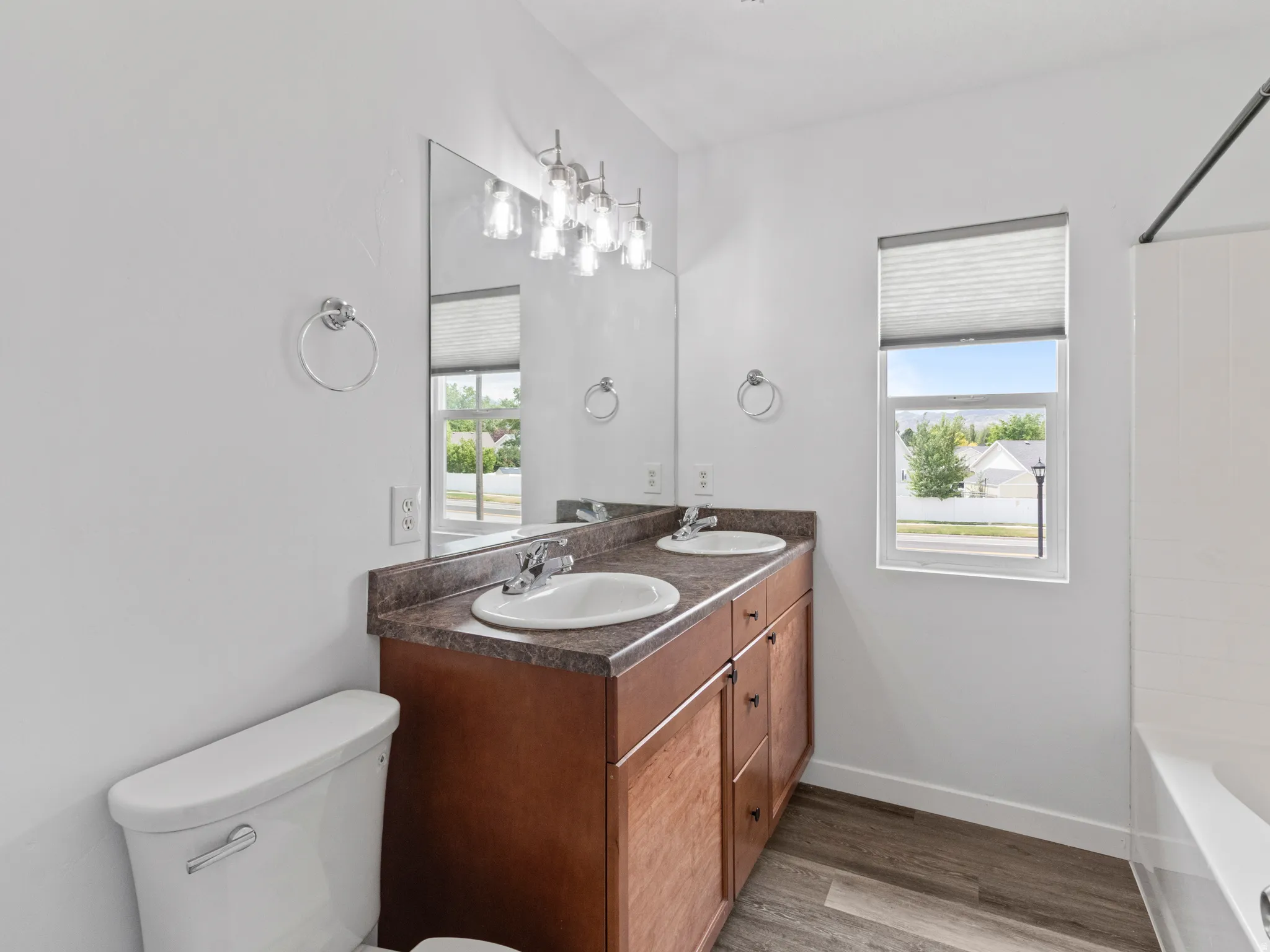 Dual vanity with wood-finish cabinetry and integrated sinks