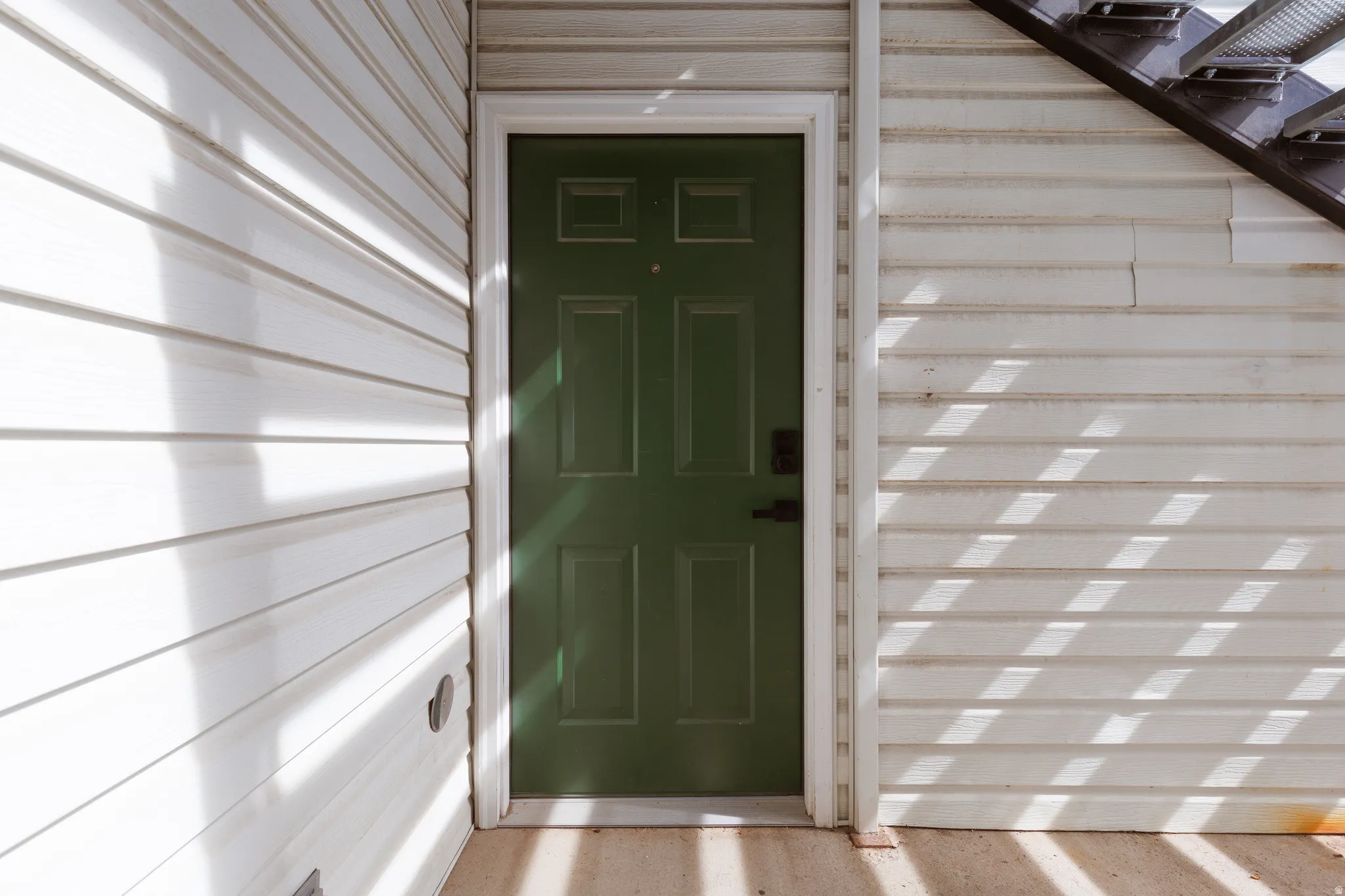 Six-panel entry door in a deep forest green hue