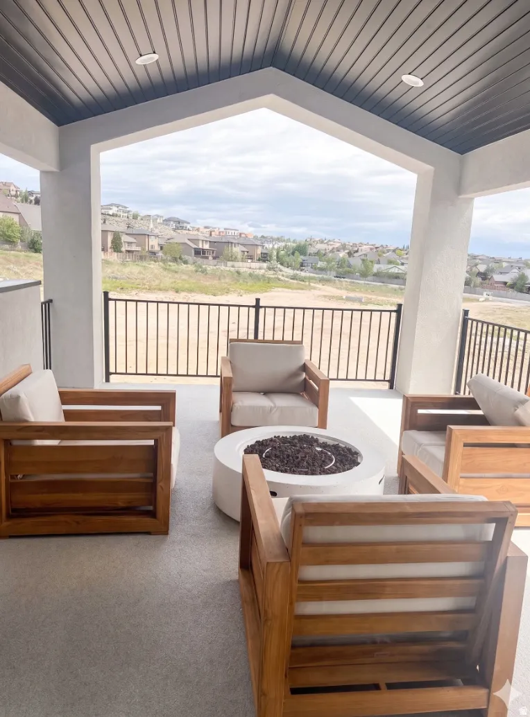 Covered outdoor patio featuring a concrete fire pit, recessed lighting, and a slatted ceiling