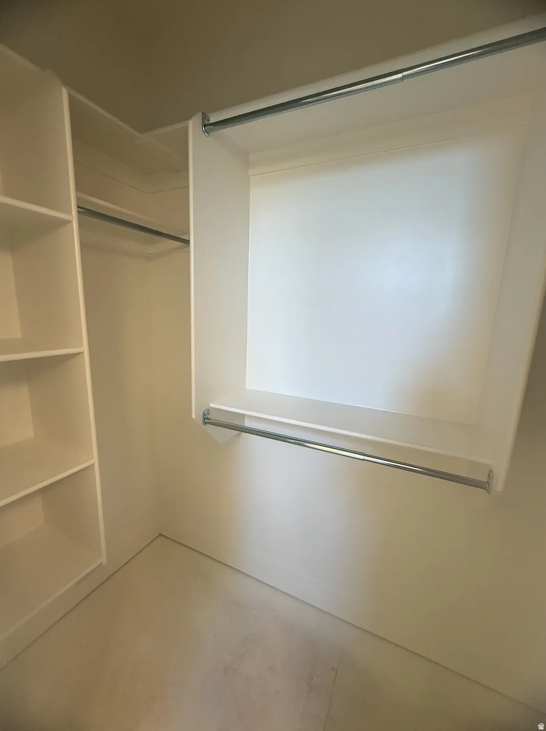 Built-in closet system featuring white shelving, multiple hanging rods, and ample storage space