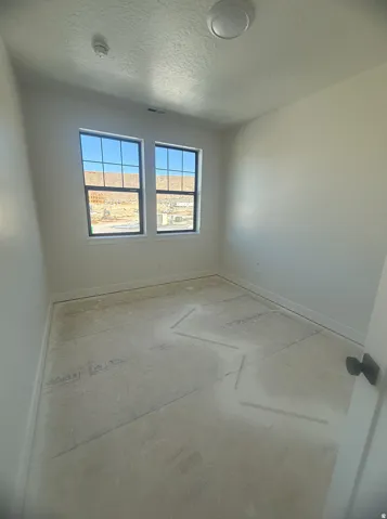 Room featuring two large windows with black frames, white walls, and a flat ceiling light fixture