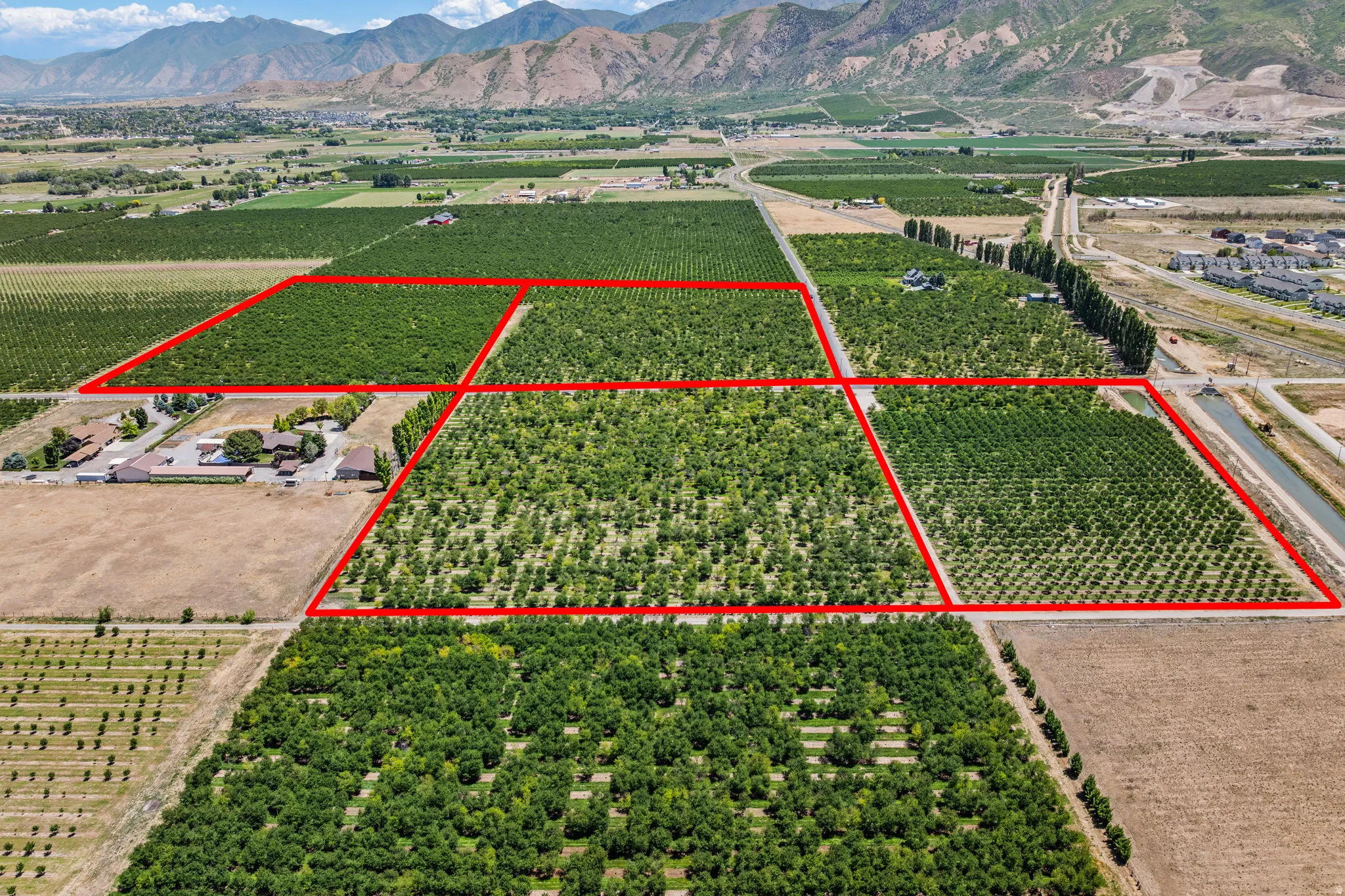 Expansive agricultural property featuring multiple cultivated fields and mature cherry trees
