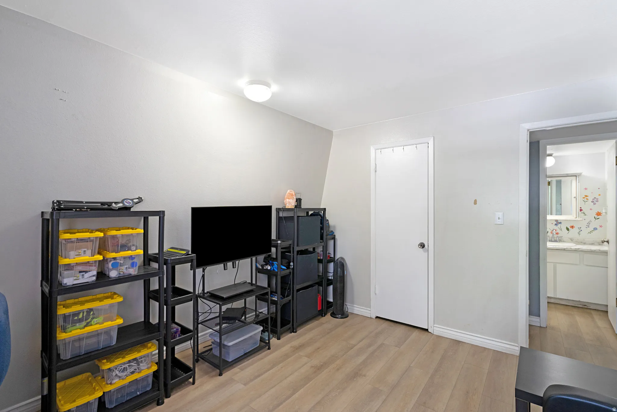 Light wood-finish flooring complements the neutral wall color